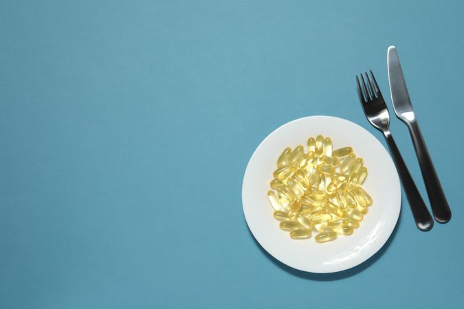 Omega pills in a bowl with a knife and fork