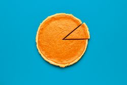 Homemade pumpkin pie isolated on a blue background
