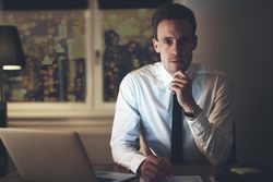 Pensive man in shirt and tie holding a pen