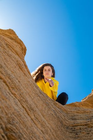Young female lending helping hand in mountains