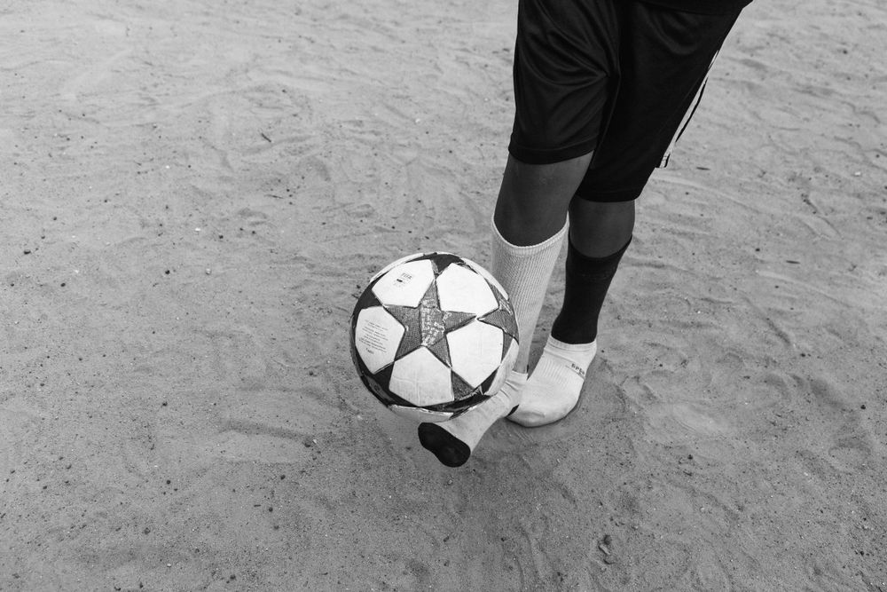Grayscale photography of person playing football