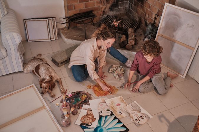 Female artist teaching boy how to paint abstract picture