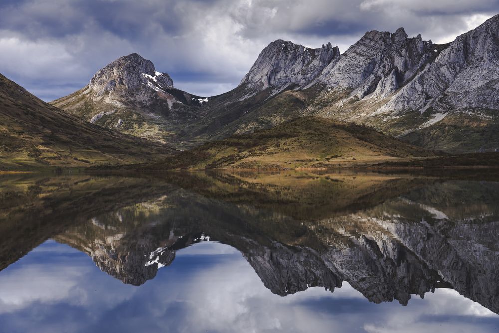 Cloudy sky over calm lake and mountains
