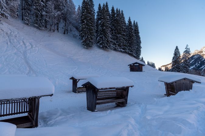 Wooden deer feeders in deep snow in the Bavarian Alps, Germany.