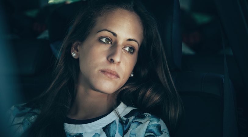 Somber woman sitting inside of car