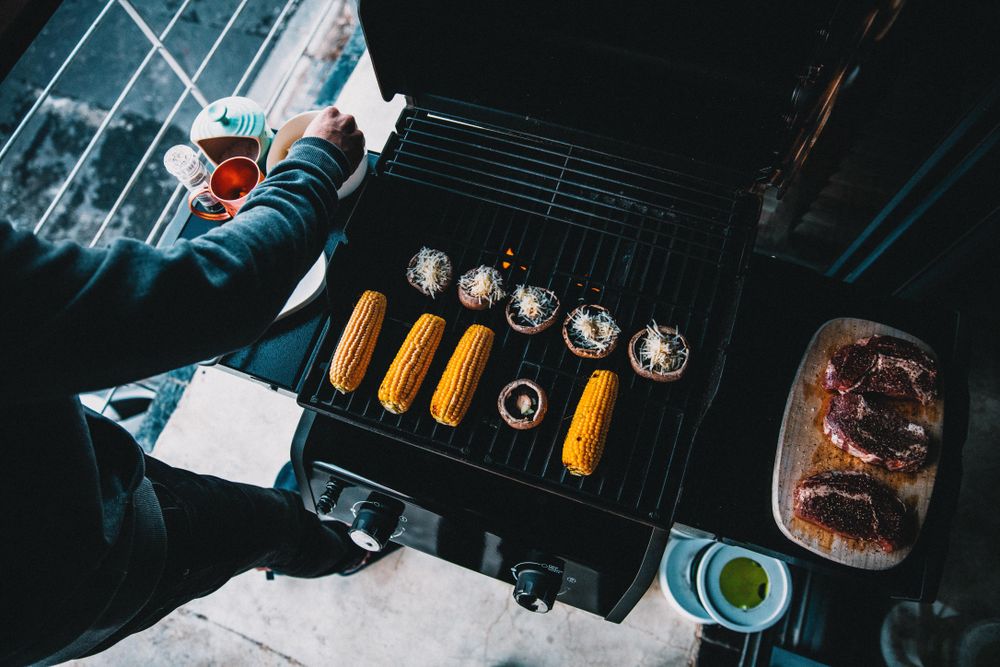 Mushrooms, corn and meat being prepared for grilling