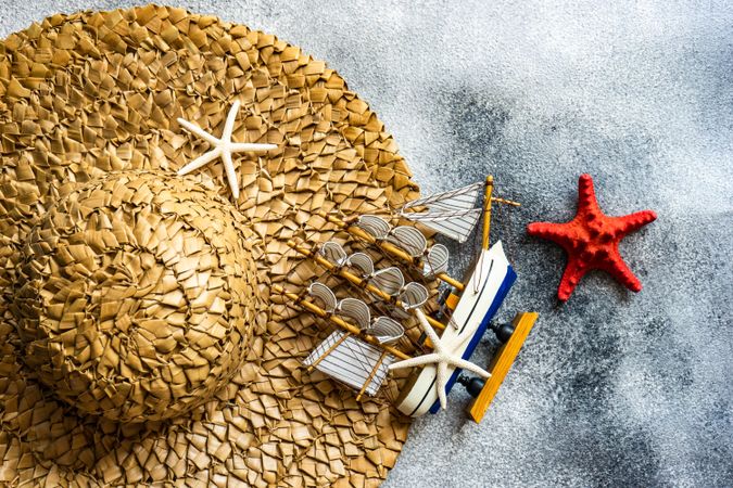Top view of straw hat with seashells as a holiday concept with copy space