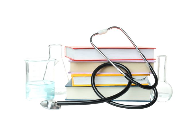 Books, stethoscope and flasks isolated on background