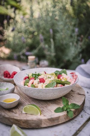 Tasty salad on wooden stand served on decorated table outside