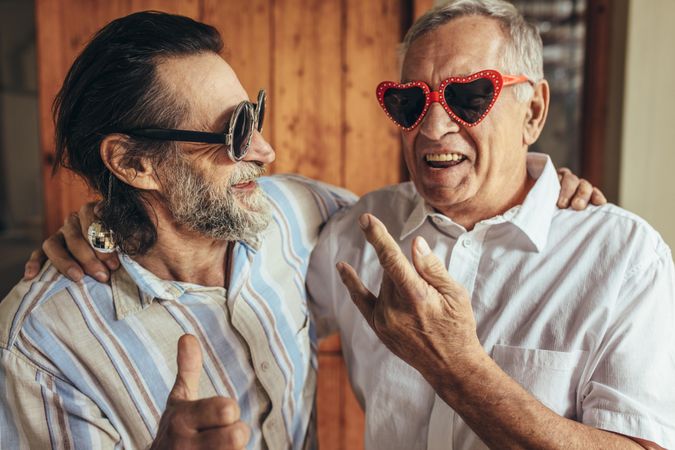 Happy older men wearing funny sunglasses making funky gestures