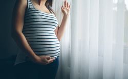 Unrecognizable pregnant holding her belly