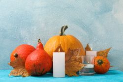 Composition with pumpkins and candles on wooden background, space for text