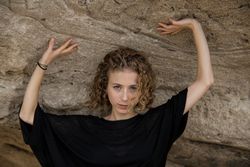 Young woman posing near stone
