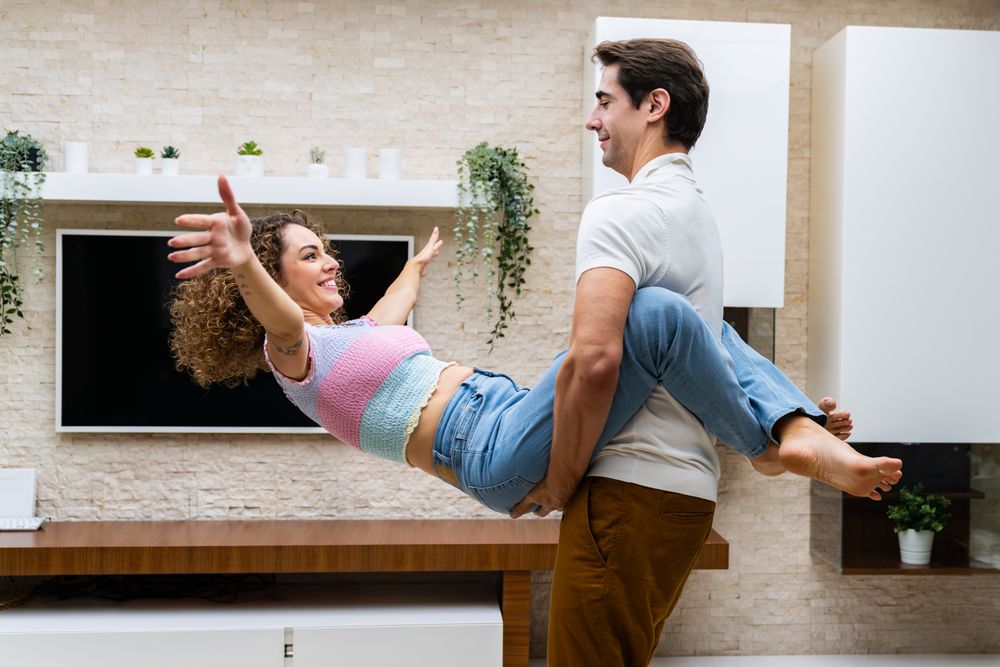Man holding woman as she hangs from his waist