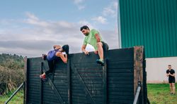 Participants in obstacle course climbing wall