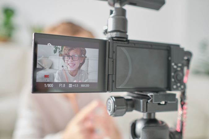 Boy recording video on professional camera at daytime