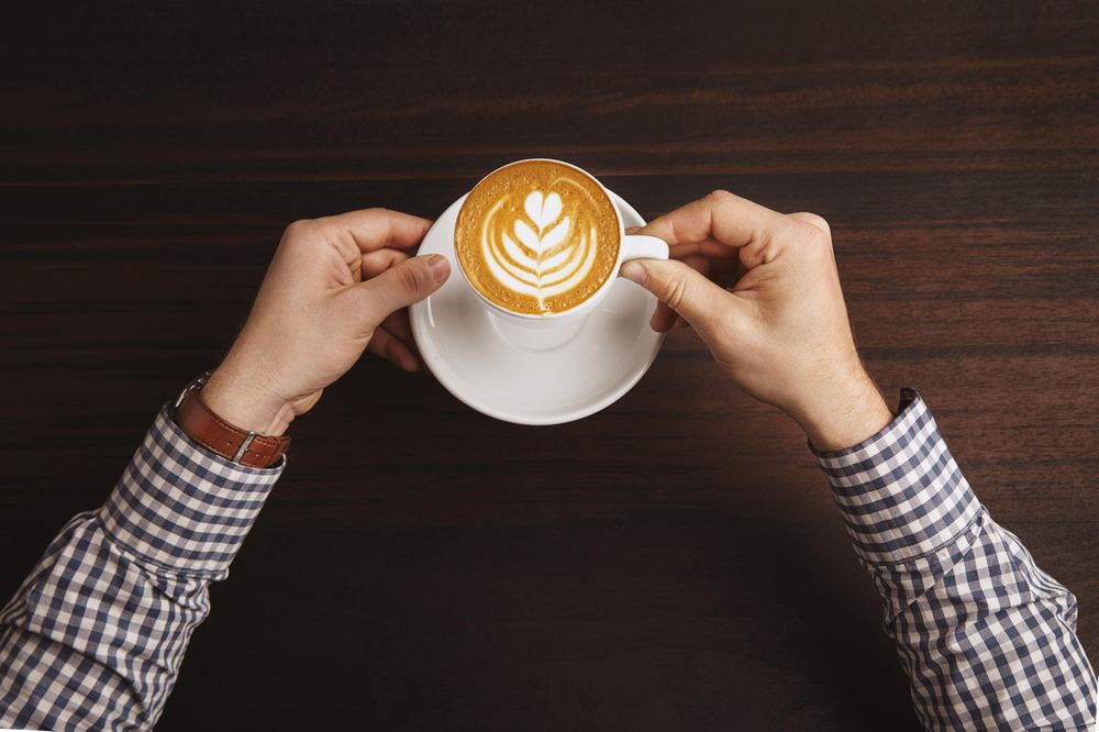 Top view of man in plaid with cappuccino