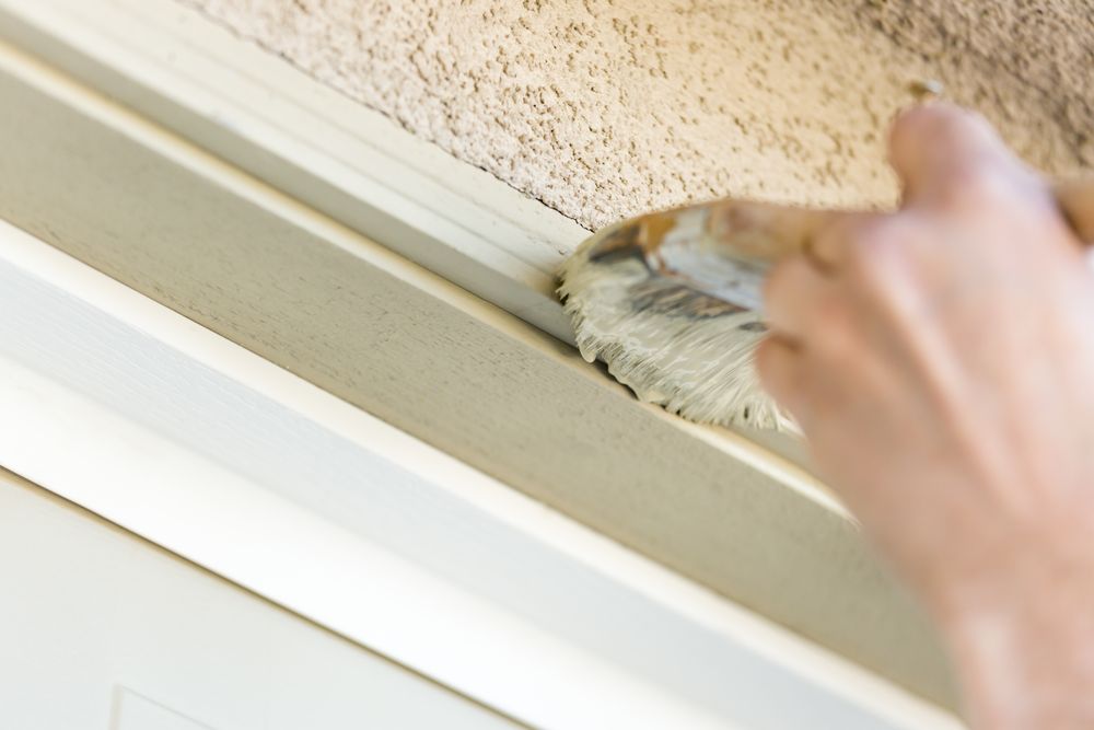 Professional Painter Cutting In With Brush to Paint Garage Door Frame