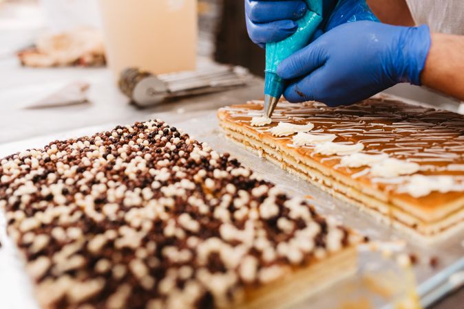Crop baker squeezing dough on tray
