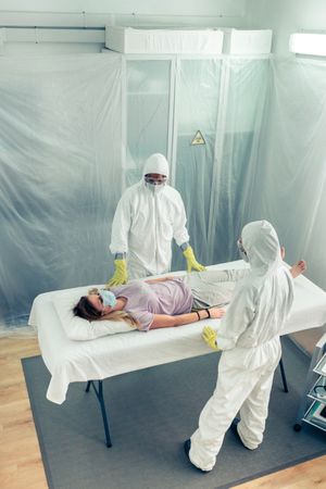 Doctors in a field hospital observing a patient