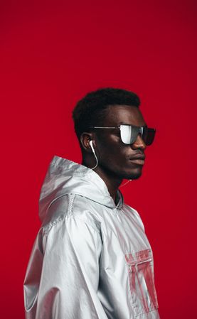 Black man in futuristic outfit against red background