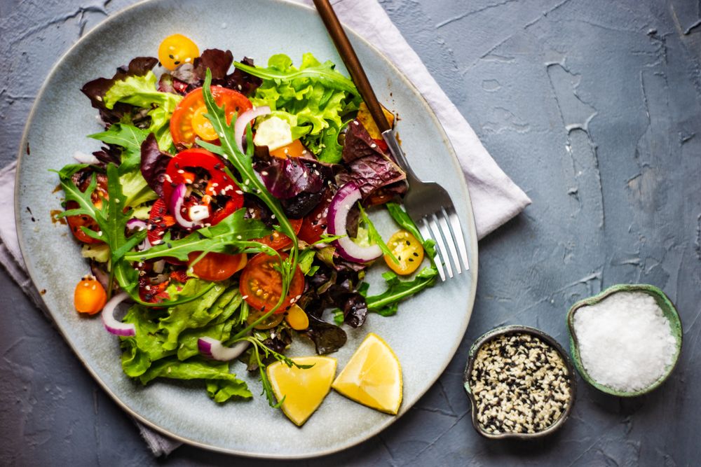 Organic vegetable salad with side of salt and sesame seeds