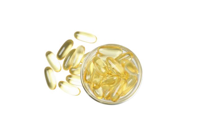 Omega pills in a bowl, isolated on blank background