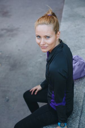Woman in sportswear sitting outside