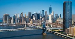 Aerial Cinematic Drone Scene Near the Manhattan and Brooklyn Bridges with NY Skyscrapers Cityscape. Beautiful Sun Shining on a Warm Summer Day. Photo of Historic Architecture