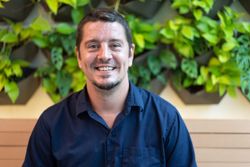 Smiling male sitting in front of greenery in restaurant