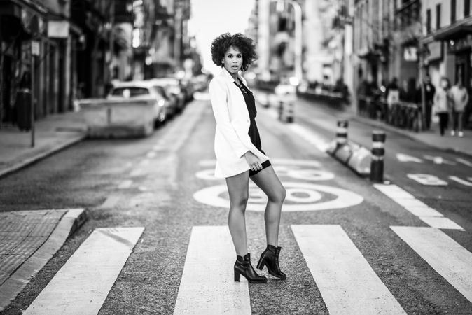 B&W female in short dress and blazer posing in the middle of street
