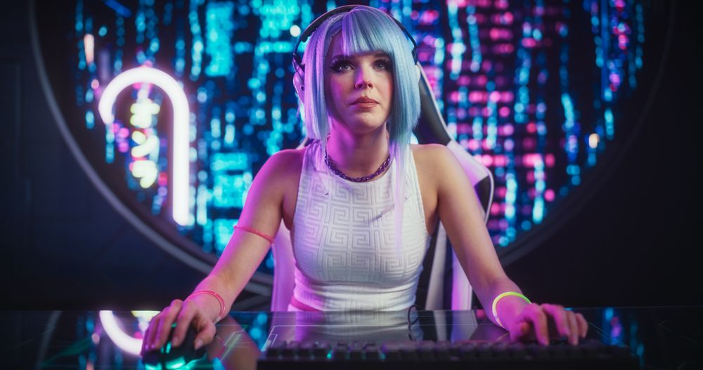 Attractive Cosplayer Playing Internet Video Game with Other Players on Desktop Computer While Sitting in Futuristic Cyberpunk Home.