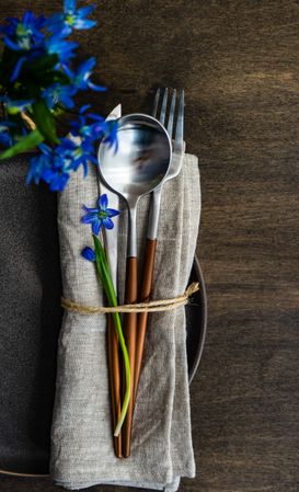 Spring table setting with blue scilla laying on napkin