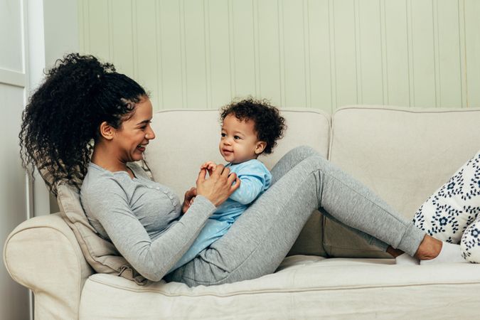 Happy mother relaxing with her toddler on the sofa
