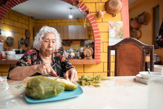 A woman is eating a fresh cooked chayote for a sn