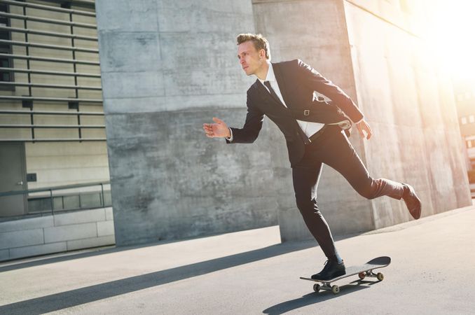 Man in business attire skateboarding