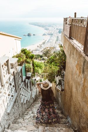 Stylish woman picturing coast from stairway