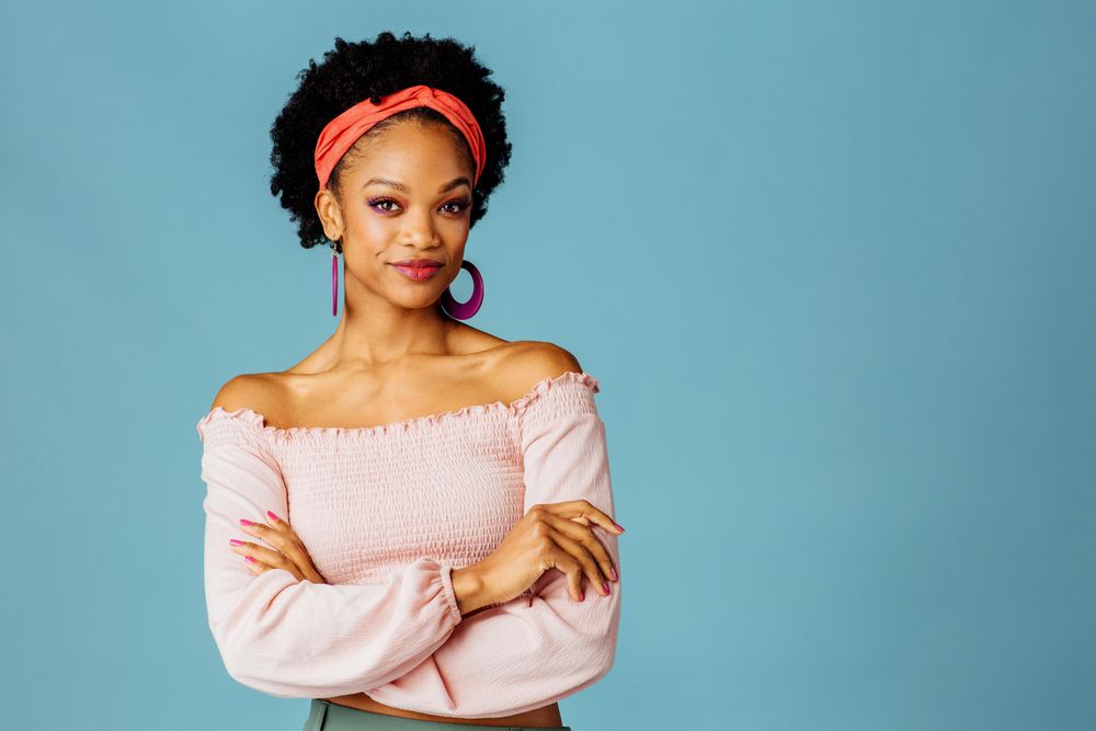 Studio shoot of curious Black woman with her arms crossed