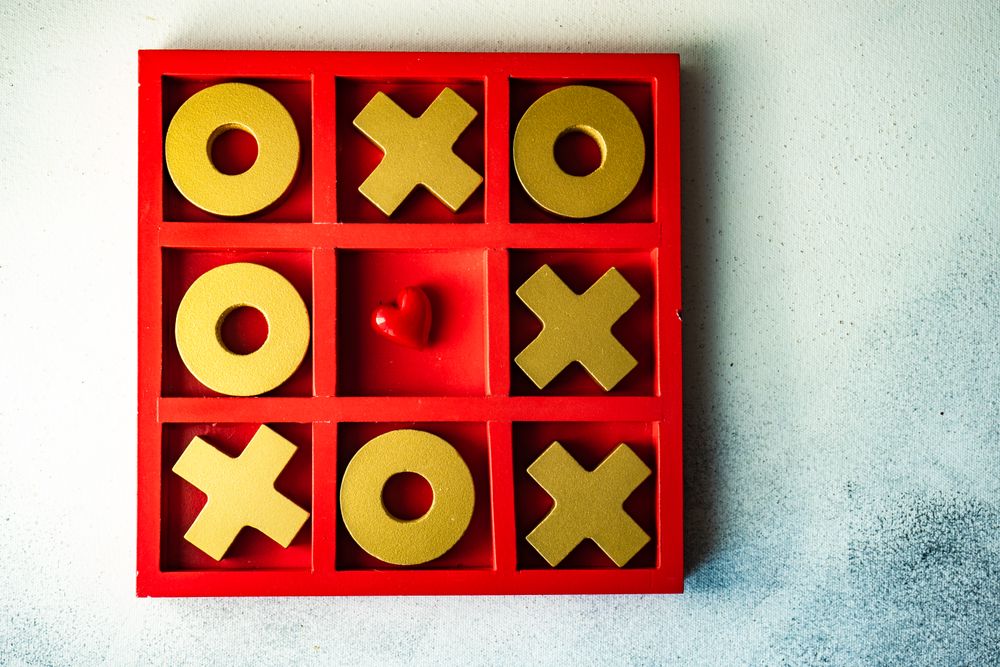St. Valentine day card concept with small heart in center of tic-tac-toe game