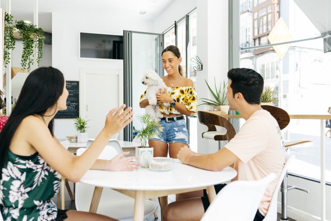 Woman with dog talking with friends in cafe