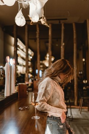 Stylish woman drinking wine in bar