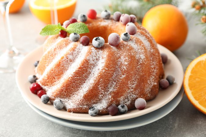 Cake with powder sugar and berries on grey table. Happy new year concept