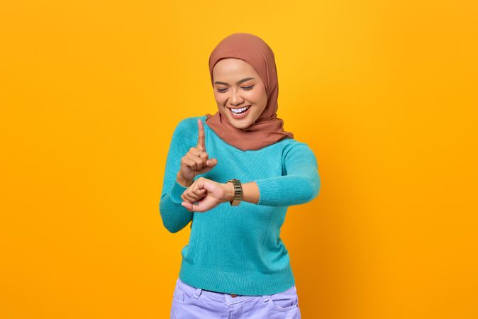 Excited Muslim woman checking the time