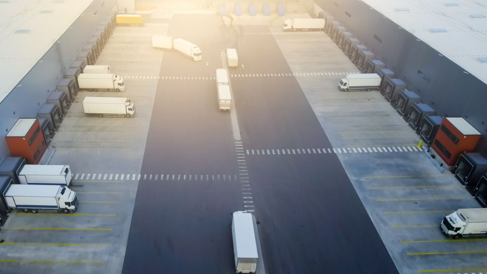 Aerial Side Shot of Industrial Warehouse Loading Dock where Many Truck