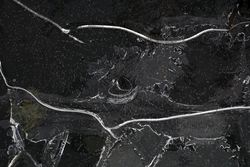 Fragment of thin ice on dark frozen river