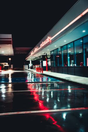 Empty retro gas station with cafe at night after rain