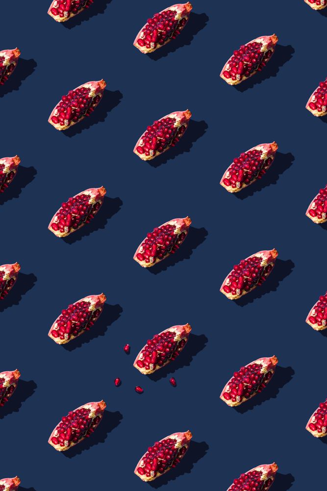 Pattern of pomegranate fruit slices on navy background