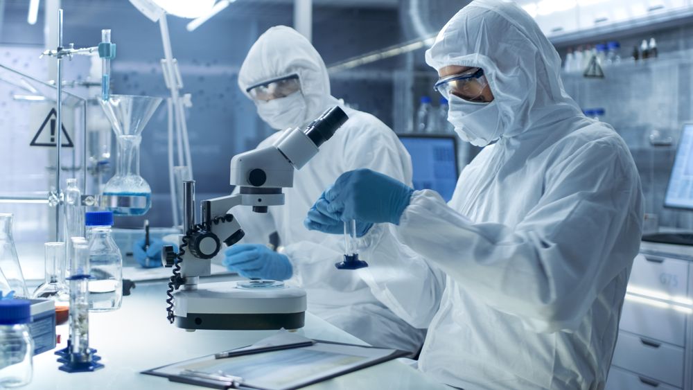 In a Secure High Level Laboratory Scientists in a Coverall Conducting a Research.