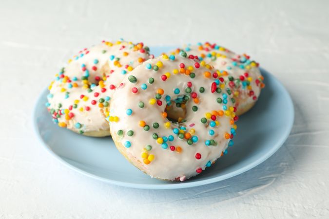 Plate with tasty donuts on plain background