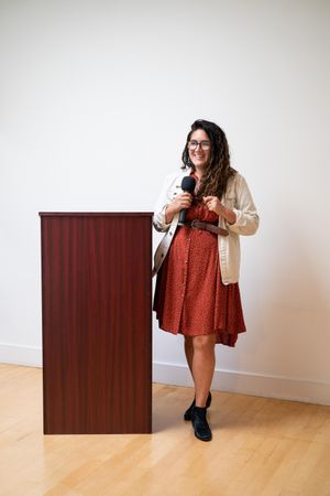 Woman giving a talk standing next to a podium